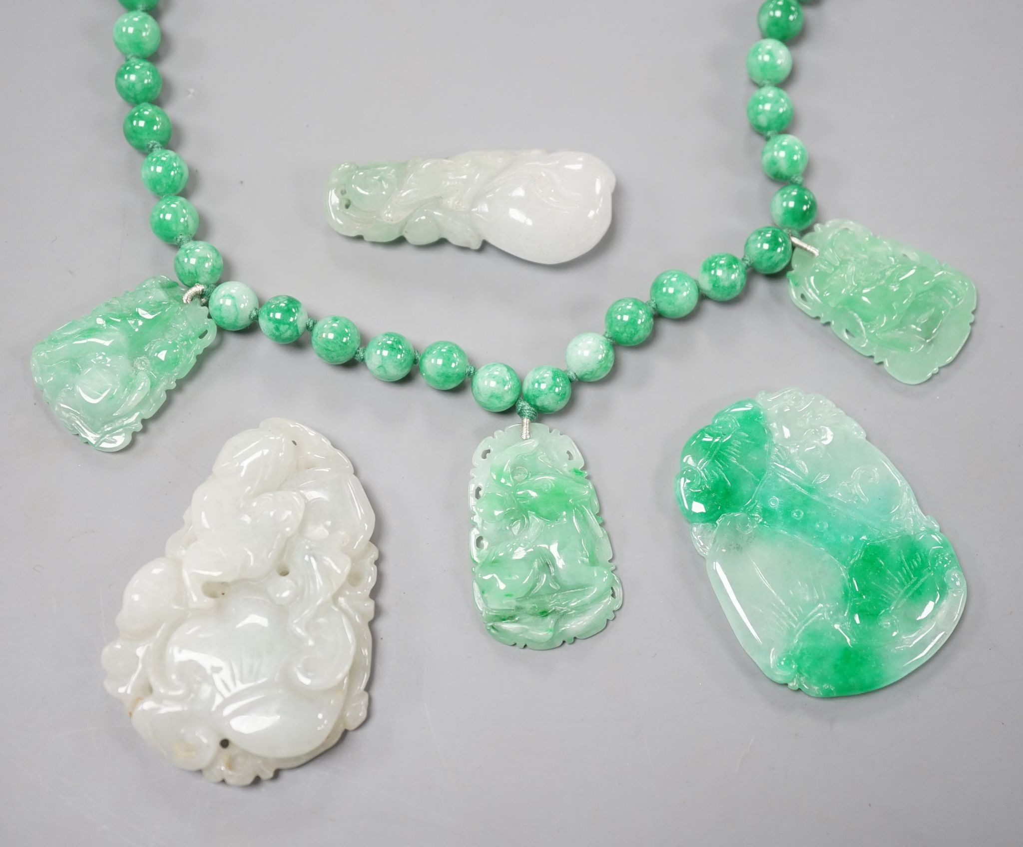 A jade bead necklace hung with three jade carvings, 49cm and three other jade carvings.